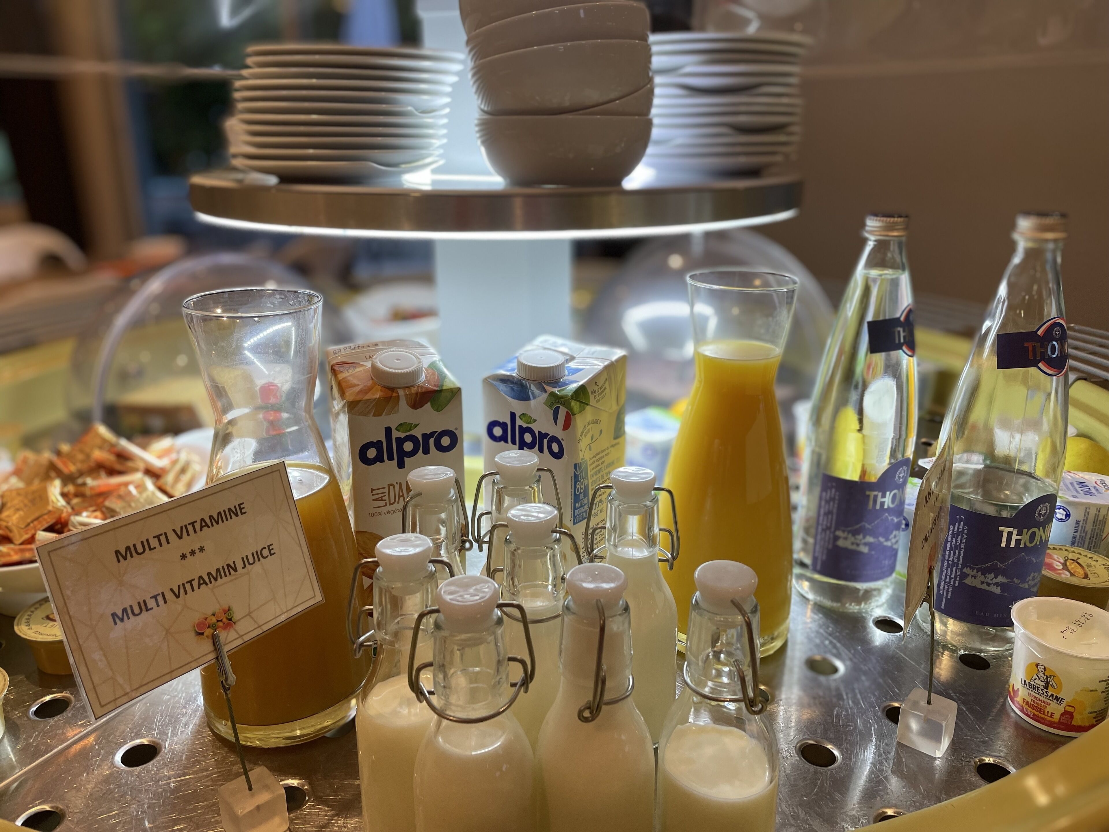 A breakfast buffet with various food and drink options, including milk, juice, and cereal.