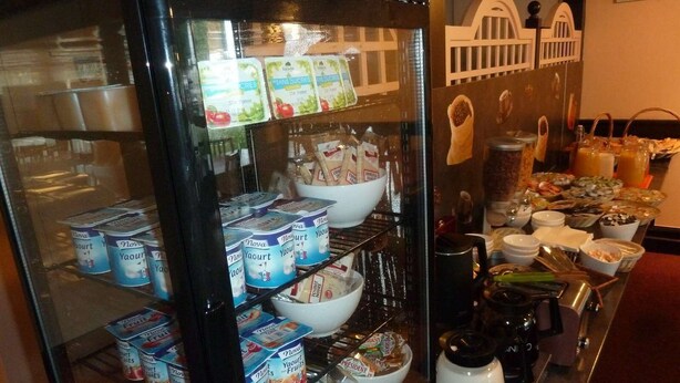 Vitrina refrigerada con diversos productos lácteos, incluyendo yogur y queso.