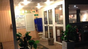 Entrada de un hotel con un cartel que indica palacio rápido, una zona de recepción y una puerta visible.