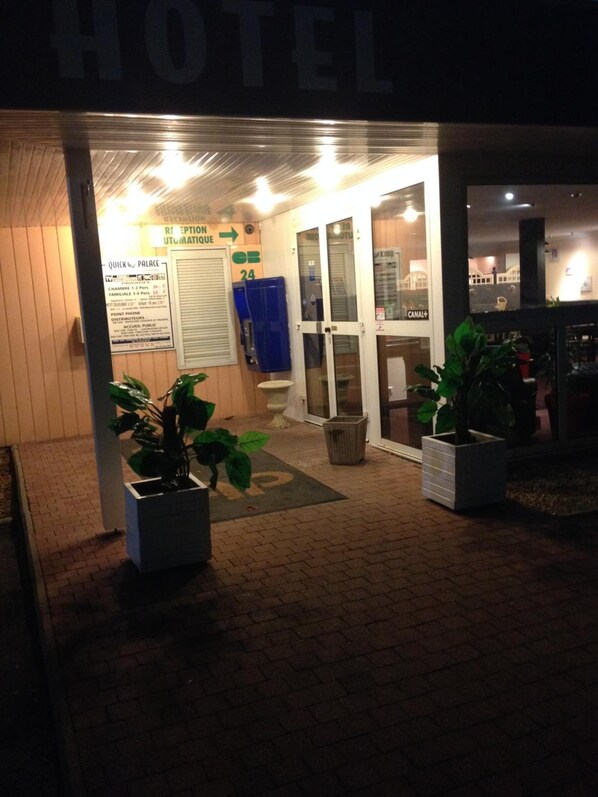 Entrada de un hotel con un cartel que indica palacio rápido, una zona de recepción y una puerta visible.