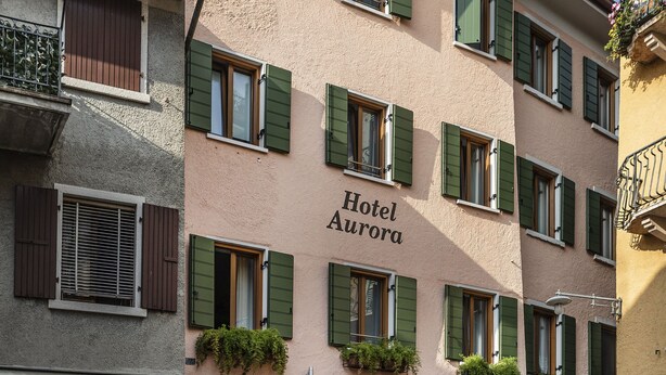 A building with a sign reading "Hotel Aurora" and "Hotel-Camere-Zimmer-Rooms" indicating it is a hotel with rooms. - Hotel Aurora (Malcesine)