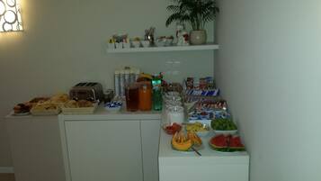 Ein reichhaltiges Buffet mit verschiedenen Speisen, darunter Obst, Backwaren und Getränke.