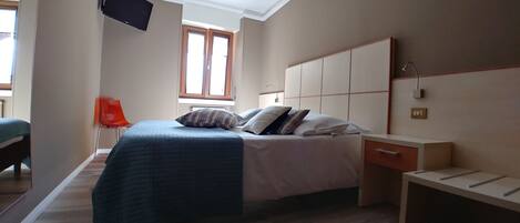 Une chambre à coucher moderne avec un lit, une table de chevet et une fenêtre.