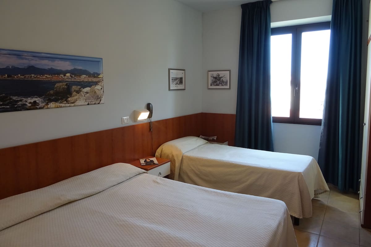 Driepersoonskamer | Een minibar, een kluis op de kamer, een bureau, verduisterende gordijnen