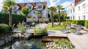 A residential building with balconies, a swimming pool, and a garden area with lounge chairs. - Hotel Volapük (Konstanz)