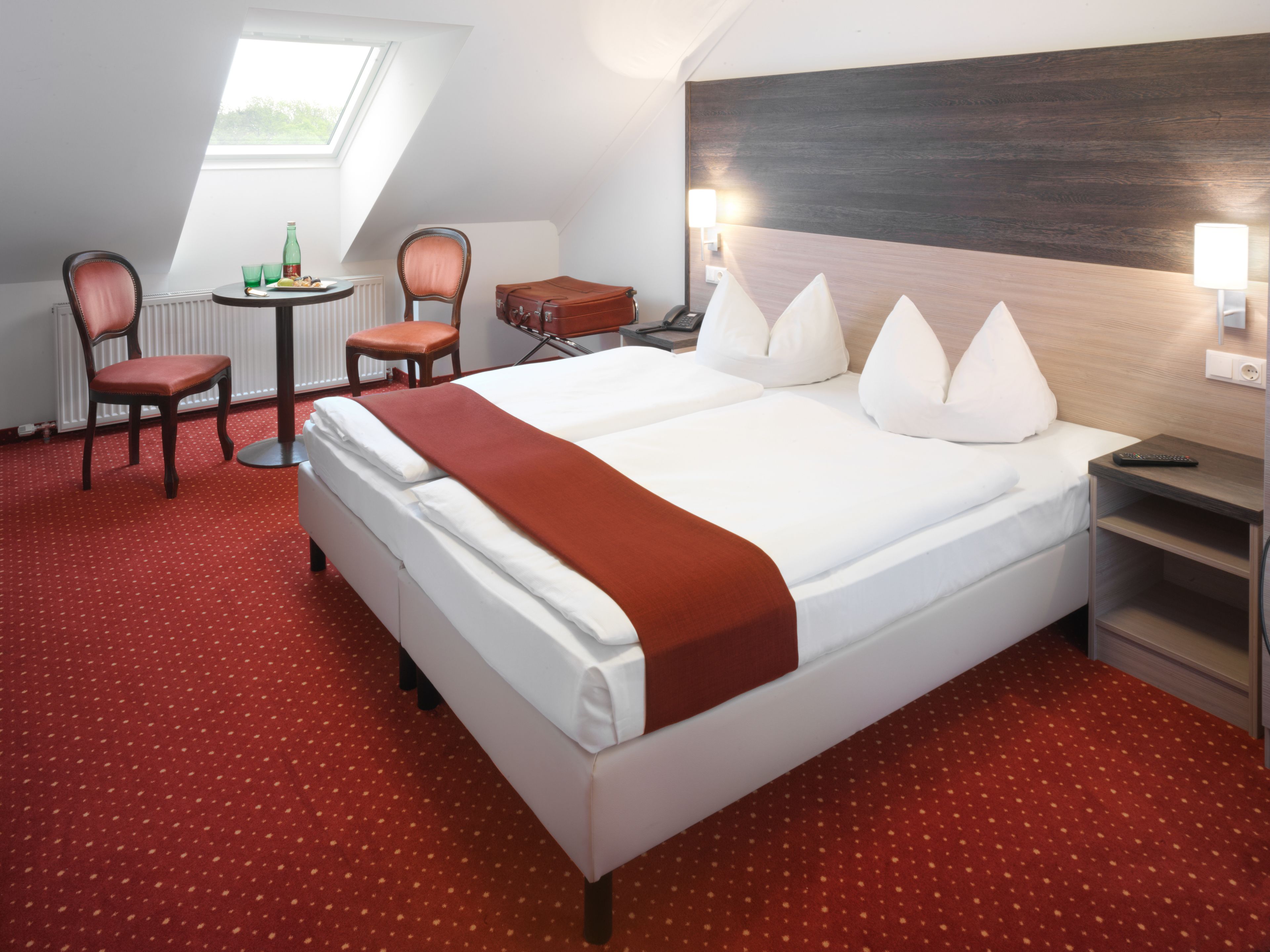 Een hotelkamer met een groot bed, een bureau, een stoel en een kleine tafel.