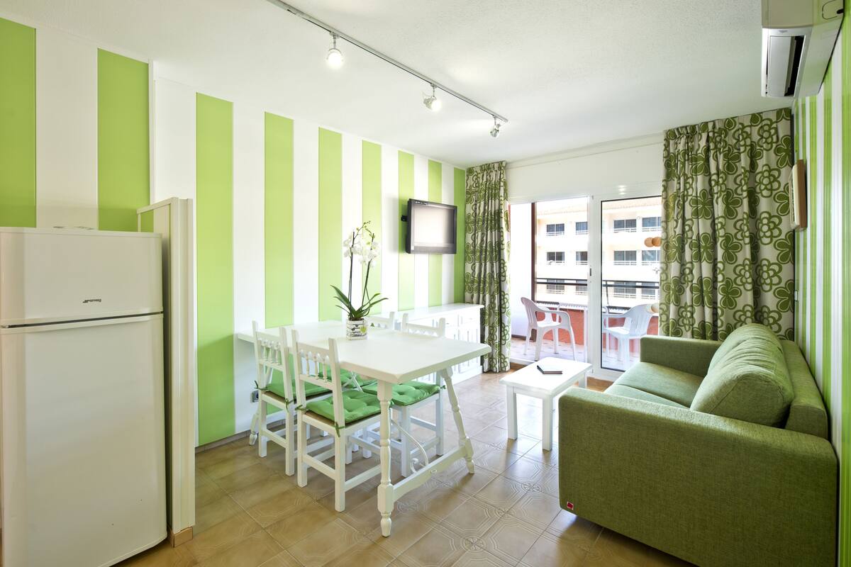 Un espacio habitable compacto con kitchenette, zona de comedor y sala de estar con vistas.