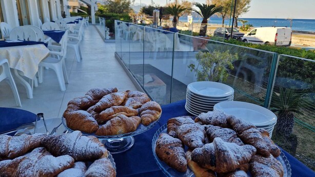 A table with pastries on a terrace overlooking a beach. - Hotel Harmony (Tortora)
