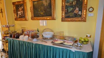 Une table de buffet garnie de différents plats et une horloge au mur.