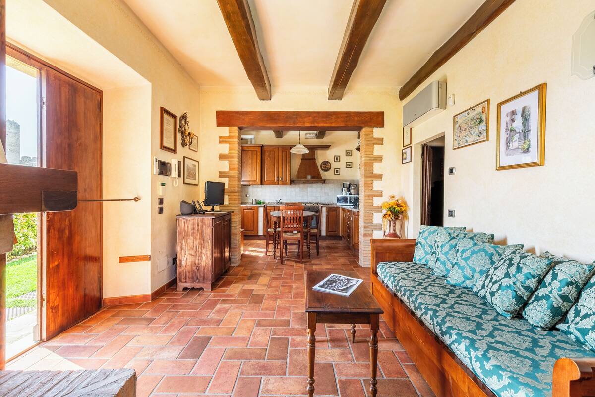 A spacious living area with a sofa, a dining table, and a kitchen in the background.