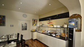 Una barra de desayuno con diferentes alimentos, un reloj en la pared y un dispensador de agua.