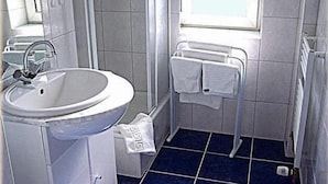 Un baño con lavamanos, toallero y ventana.