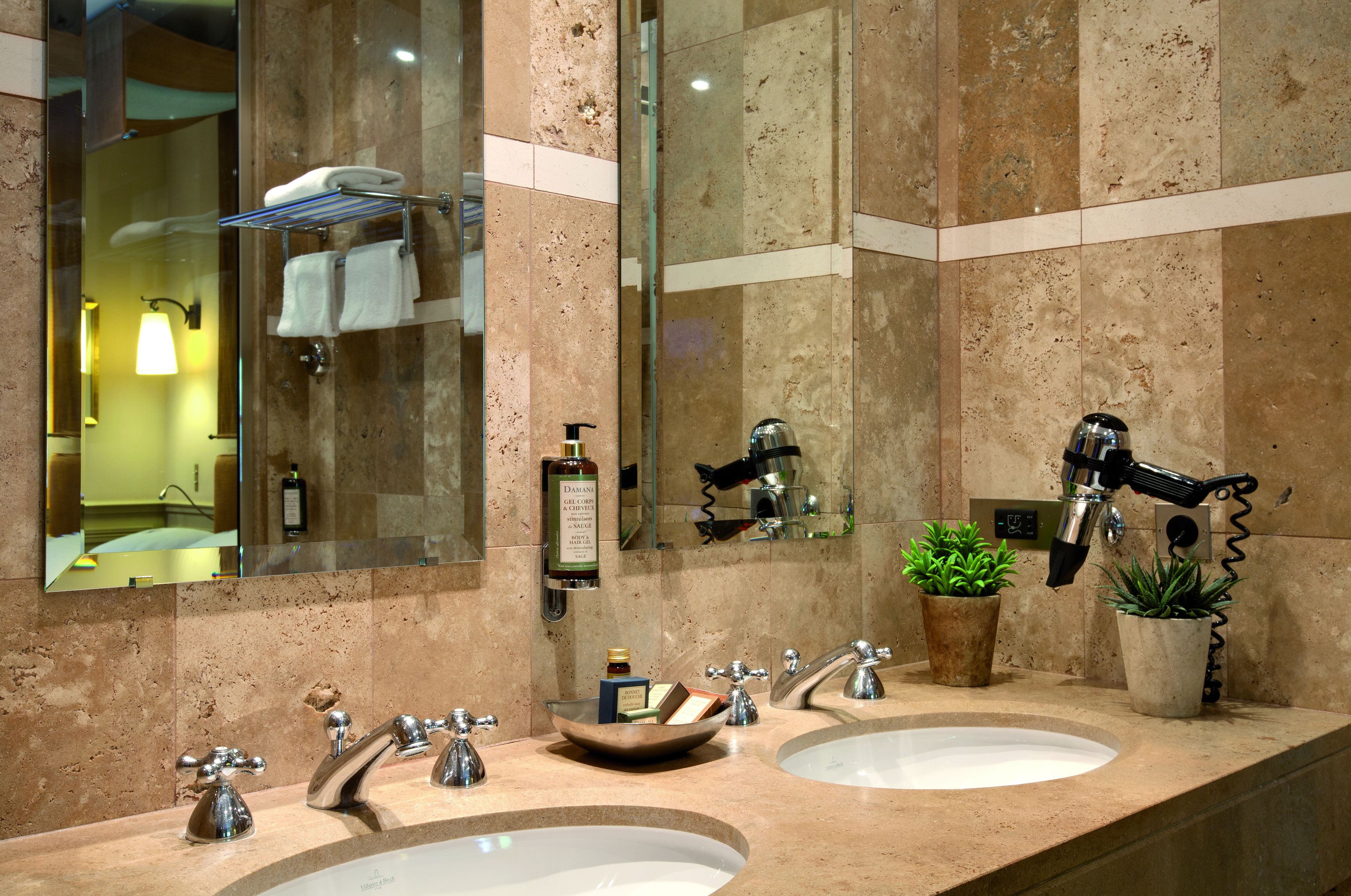 A bathroom with two sinks, a mirror, and a towel rack.