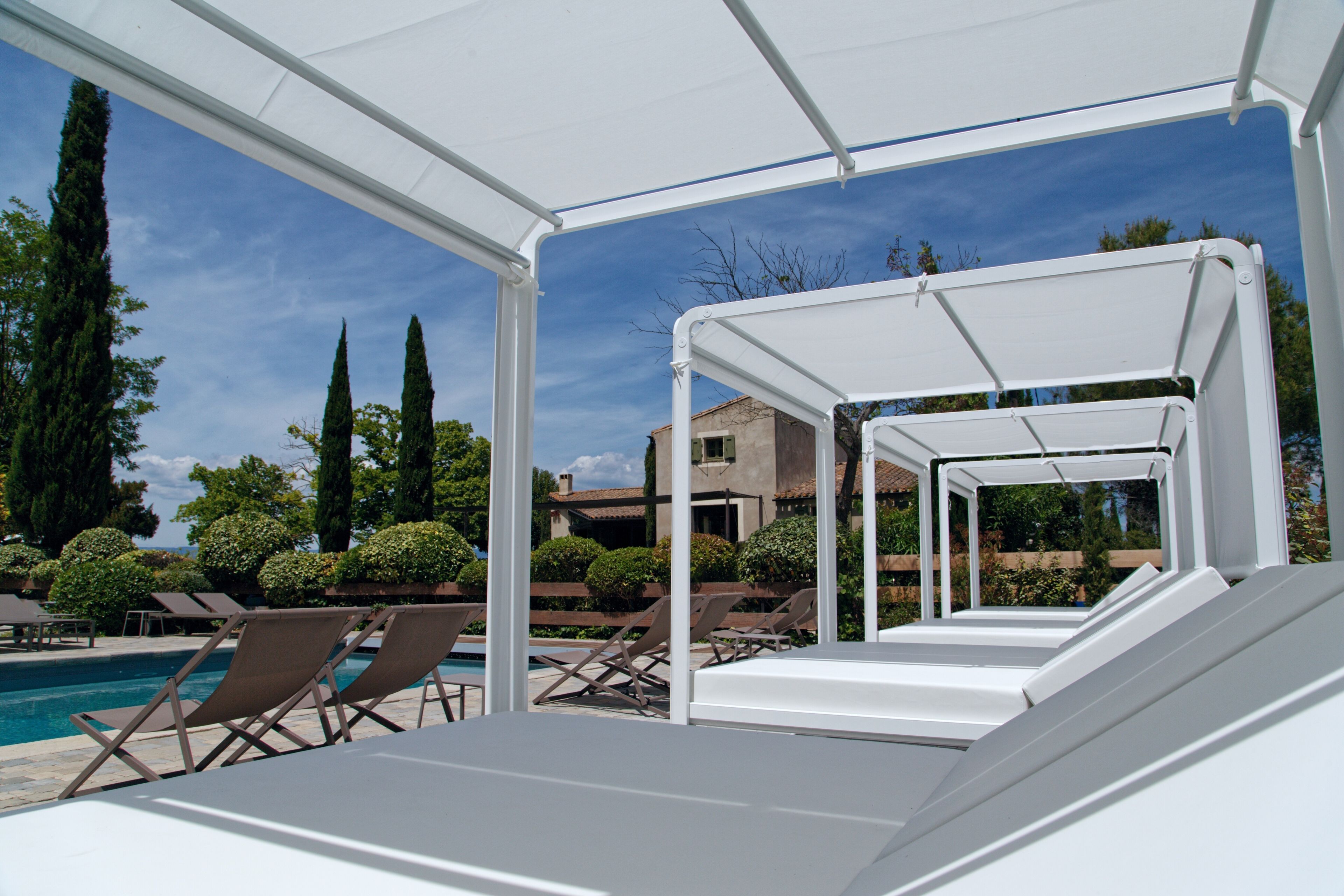 Zona de piscina techada con sillones de descanso y vista al paisaje circundante.
