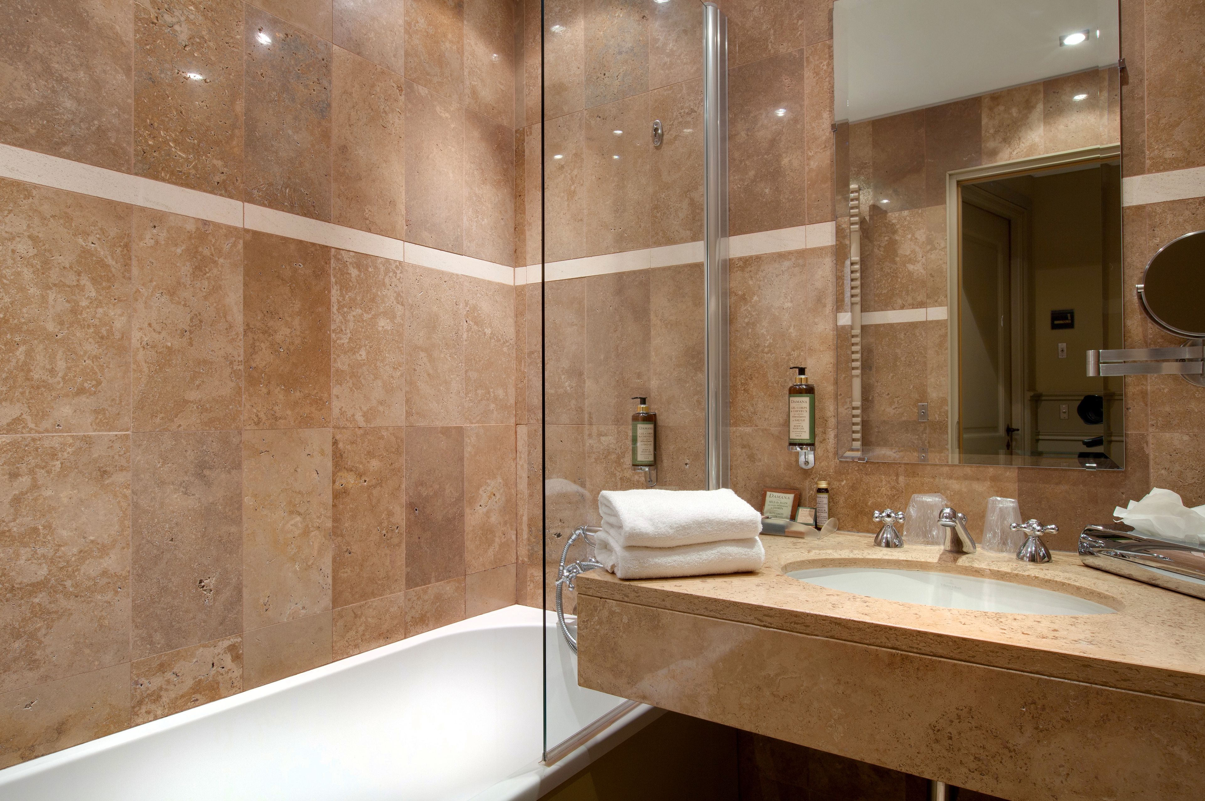 Une salle de bain moderne avec un grand miroir, une baignoire et un lavabo avec un meuble-vasque.