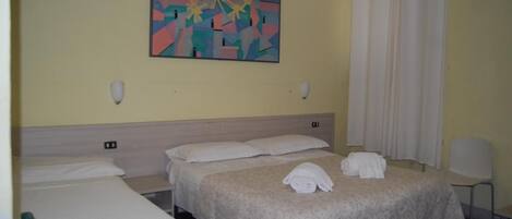 Habitación de hotel con dos camas, un cuadro en la pared y una silla.