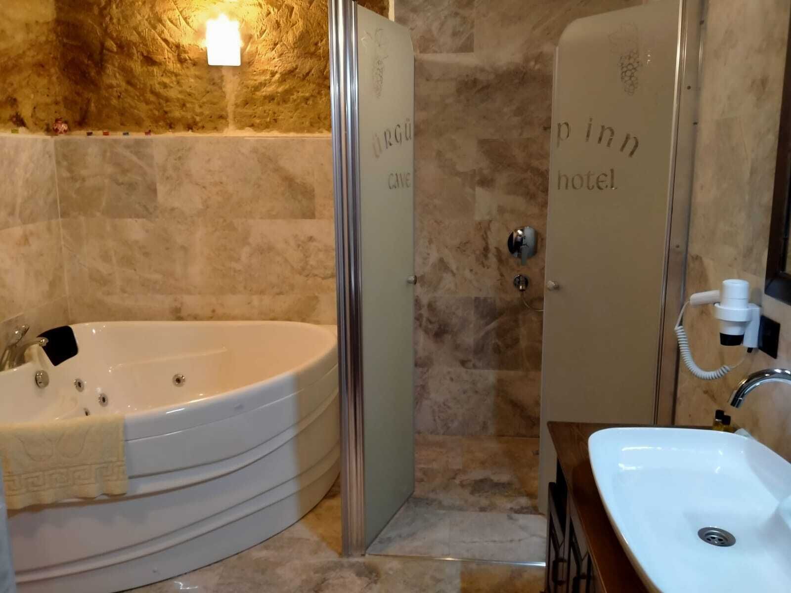 A bathroom with a bathtub, a shower, and a sink.