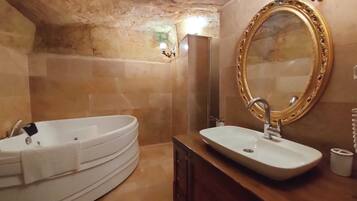 Un bagno con vasca, lavandino, specchio e porta asciugamani.