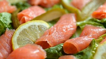 A close-up of a salad with salmon and lemon slices.