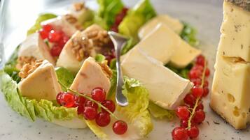 Ensalada con queso, nueces y grosellas rojas en un plato.