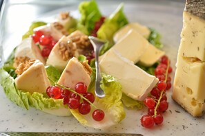 A salad with cheese, walnuts, and red currants on a plate. - Schöngarten Garni (Lindau)