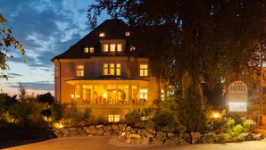 A large, two-story hotel with a stone facade and multiple windows. - Schöngarten Garni (Lindau)