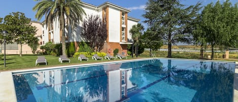 Alberca al aire libre por temporada y sombrillas en la alberca