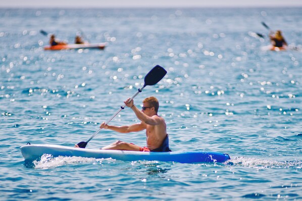 Una persona haciendo kayak en aguas tranquilas.
