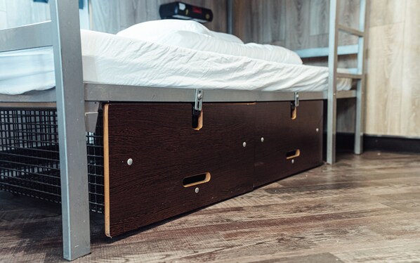 A bunk bed with a lower compartment that appears to be a storage space.