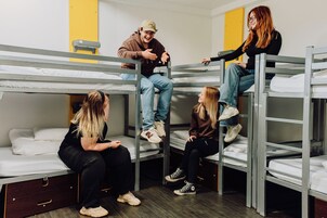 Bunk beds with occupants, a wooden floor, and a yellow wall.