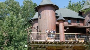 A wooden building with a tower, a balcony with a railing, and a wooden staircase. - Domaine de Dienné (Dienne)