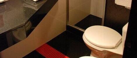 A modern bathroom with a shower, toilet, and sink.