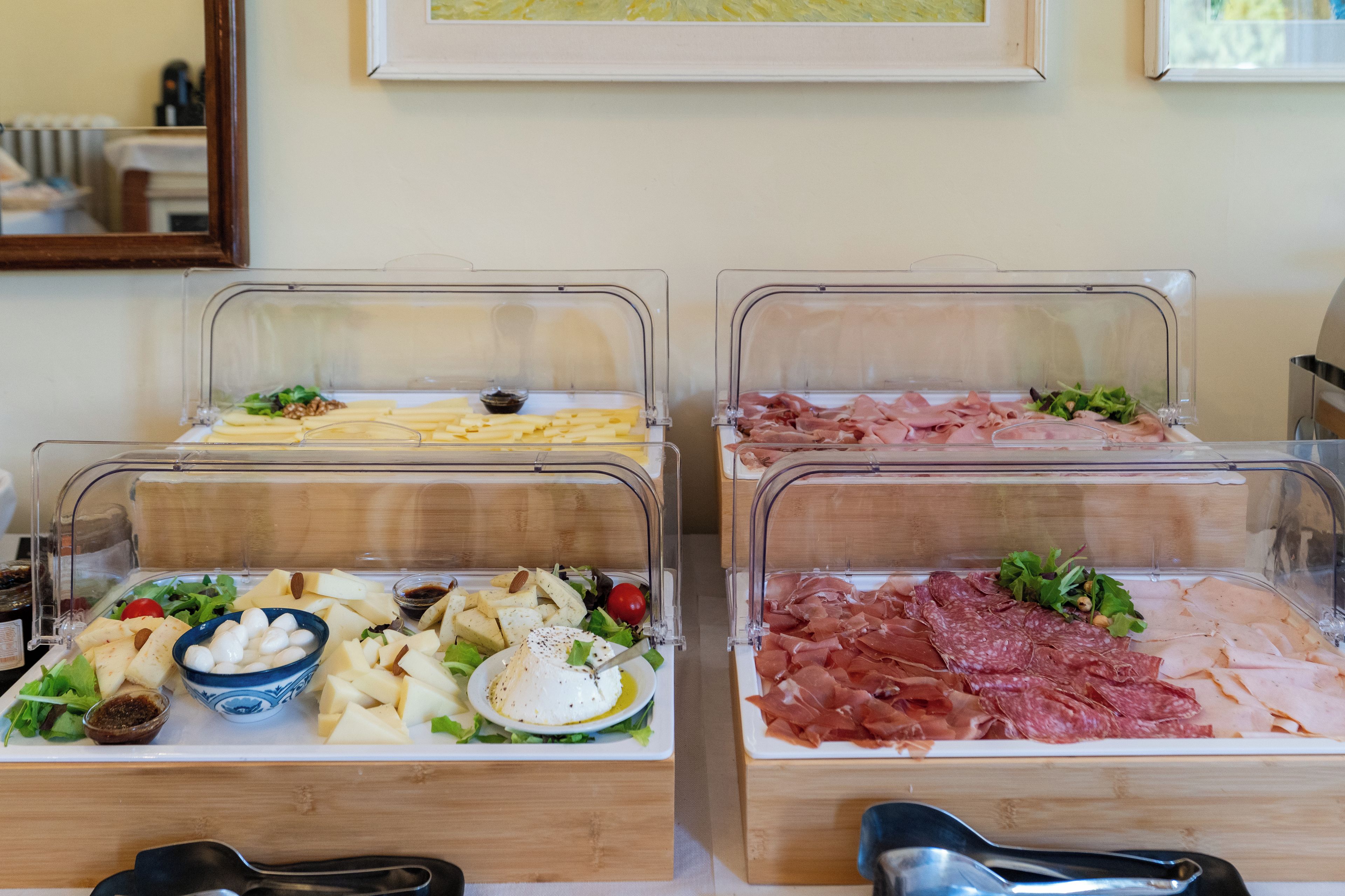 Ein Buffet mit verschiedenen Speisen, darunter Käse, Fleisch und Salate.