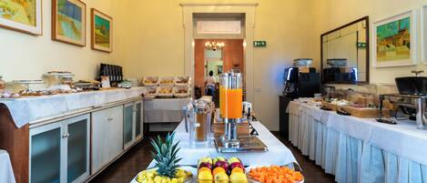 A buffet setup with various food items and a juice dispenser.