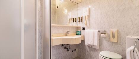 Une salle de bain moderne avec une douche à parois de verre, un meuble-lavabo et des toilettes.
