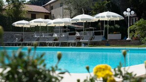 A pool area with lounge chairs and umbrellas.