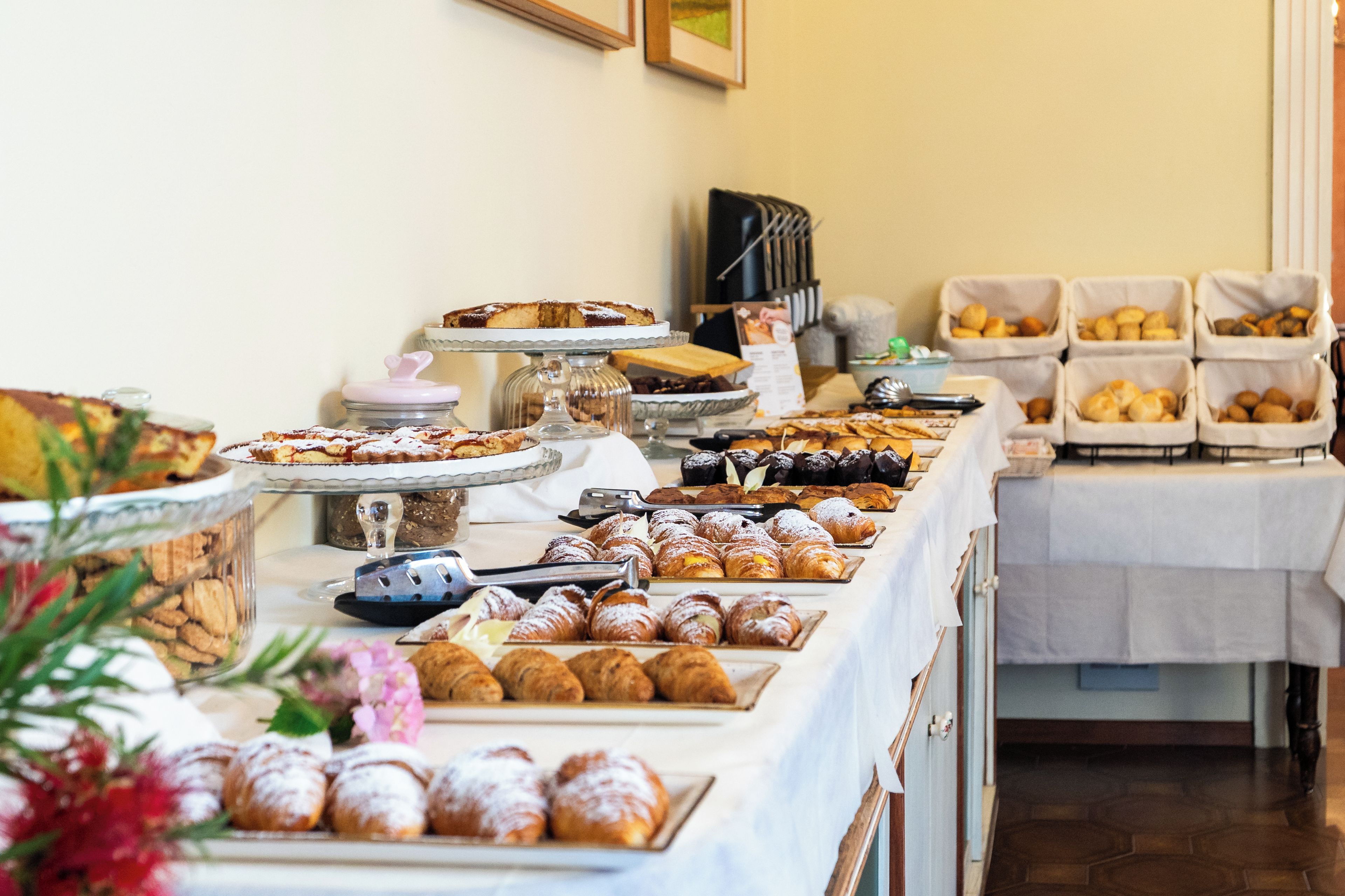 A buffet table with various baked goods and pastries.