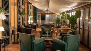 A room with a pool table, green upholstered chairs, a sofa, and potted plants. - Hotel Maderno by Double Hospitality (Toscolano Maderno)