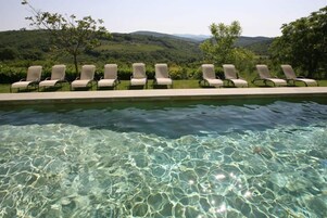 Una piscina al aire libre de temporada, sillones reclinables de piscina