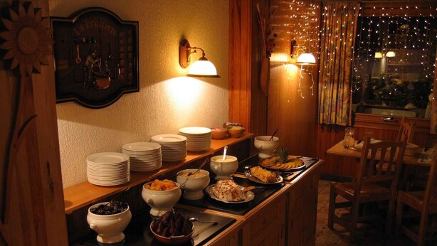 A breakfast buffet with various dishes and a wooden counter. - Le Gotty (La Clusaz)