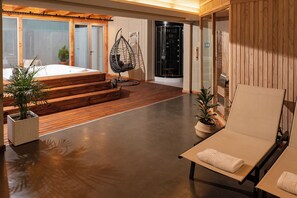 A modern interior with a wooden deck, a hanging chair, a sauna, and a lounge area. - Crans Montana Hotel (San Carlos de Bariloche)
