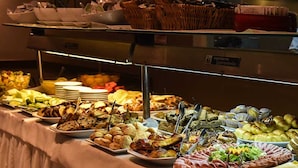 A buffet with various food items including pastries, meats, and salads. - Crans Montana Hotel (San Carlos de Bariloche)