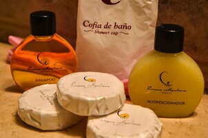 Um frasco de shampoo, um gorro de banho e um frasco de condicionador.