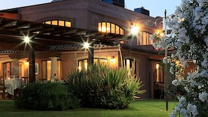 A building with a covered patio area, outdoor seating, and well-lit surroundings. - I Ginepri (Quartucciu)