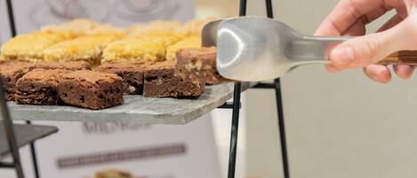 Une vitrine remplie de pâtisseries, avec une pancarte indiquant la présence de brownies.