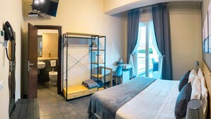 A hotel room with a bed, a desk, a chair, a wardrobe, a bathroom, and a TV. - Hotel Ristorante Centosedici (Terracina)
