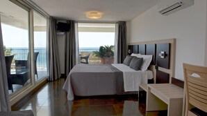 A hotel room with a bed, a desk, and a view of the ocean. - Hotel Ristorante Centosedici (Terracina)