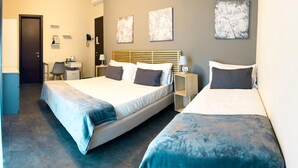 A hotel room with two beds, a desk, a chair, a phone, and artwork on the walls. - Hotel Ristorante Centosedici (Terracina)