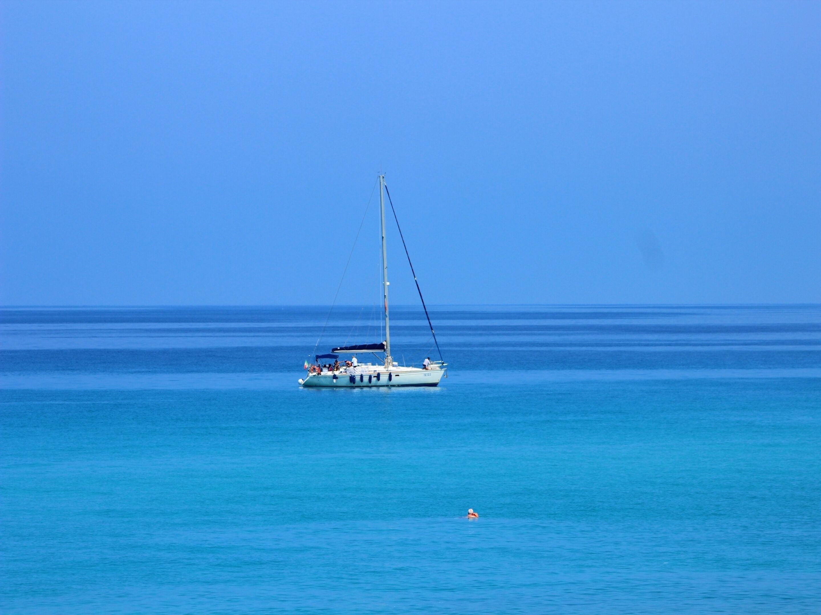 Un velero en aguas azules tranquilas.