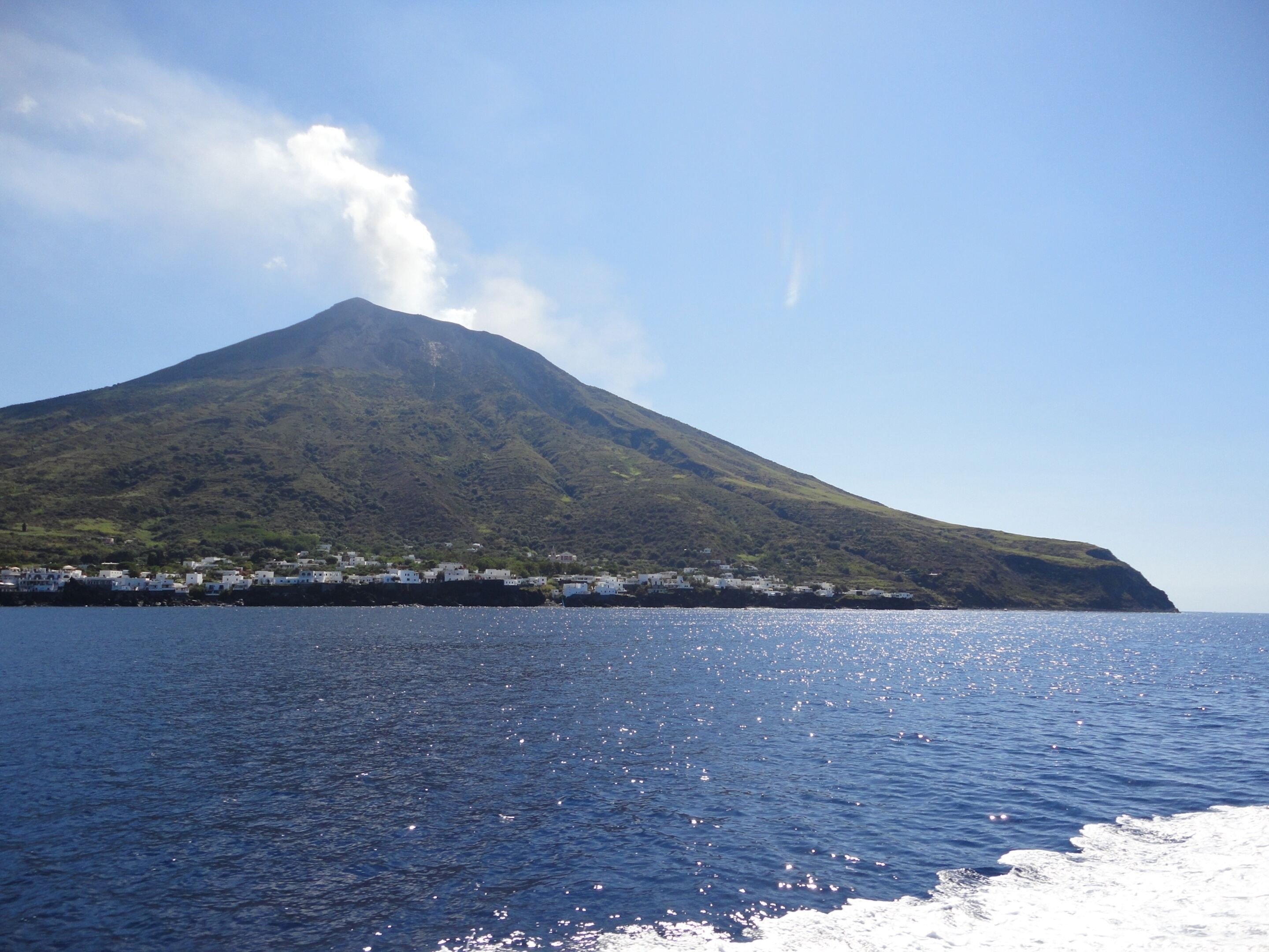 A coastal view with a mountain and a small settlement.